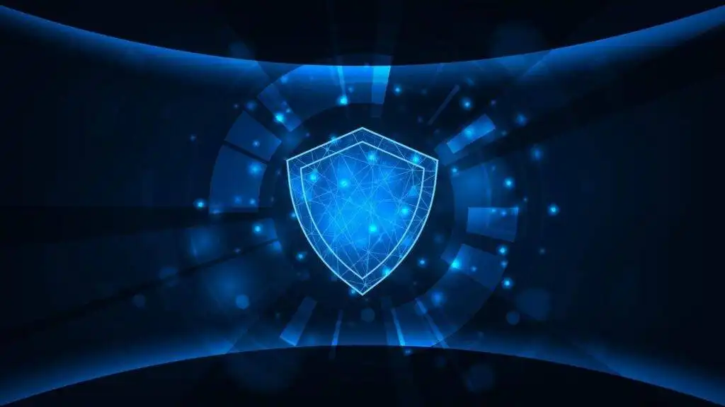 A digital illustration of a glowing blue shield surrounded by abstract light effects and geometric shapes, symbolizing cybersecurity or digital protection.